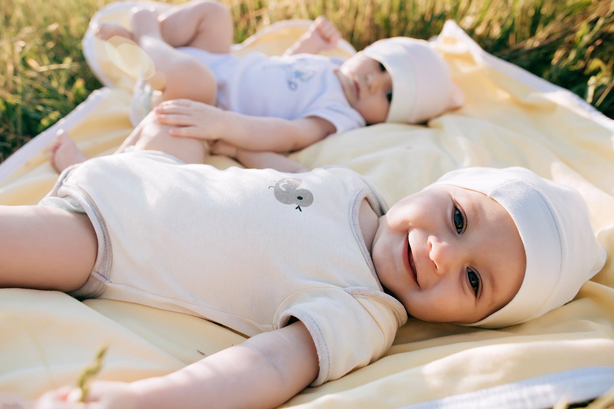 Babies Laying on a Blanket on the Grass Babies Laying on a Blanket on the Grass